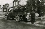 Tie- ja vesirakennuspiirin Federal-auto (vuosimallia 1939) suolaamassa tietä Haikosen talon edessä vuonna 1939. Takana myös poliisi Laineen talo. Kuva Tuusulan museo